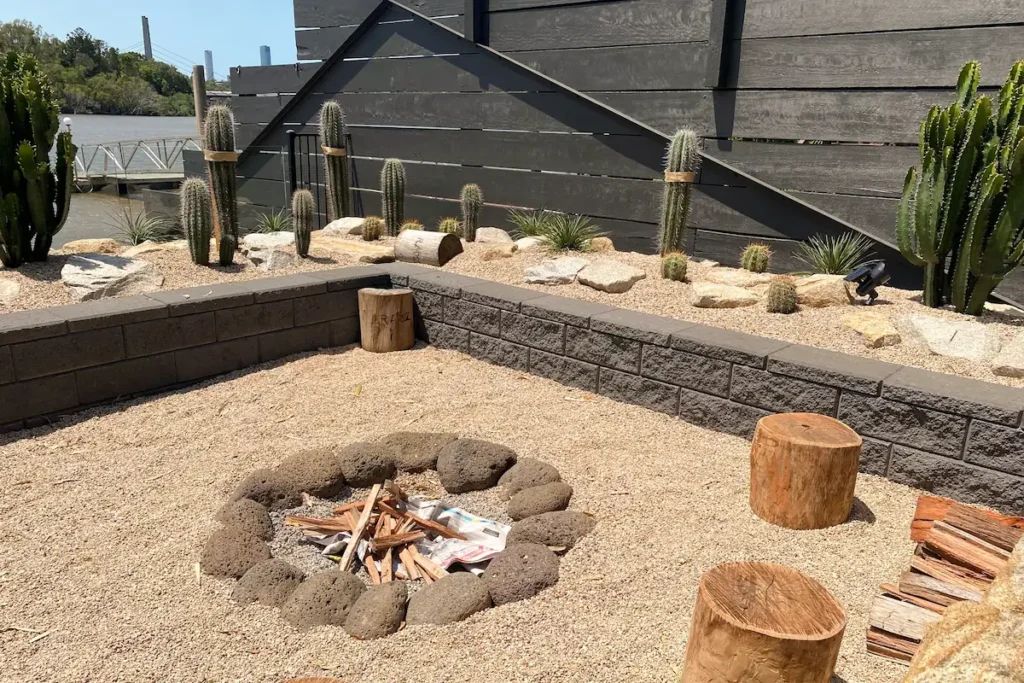 A sandy fire pit surrounded by cactus gardens